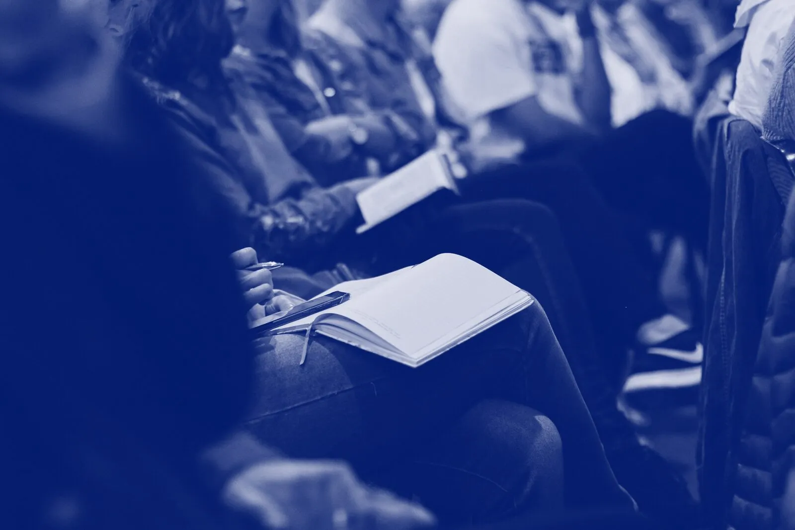 Seated learners with open notebooks during a session