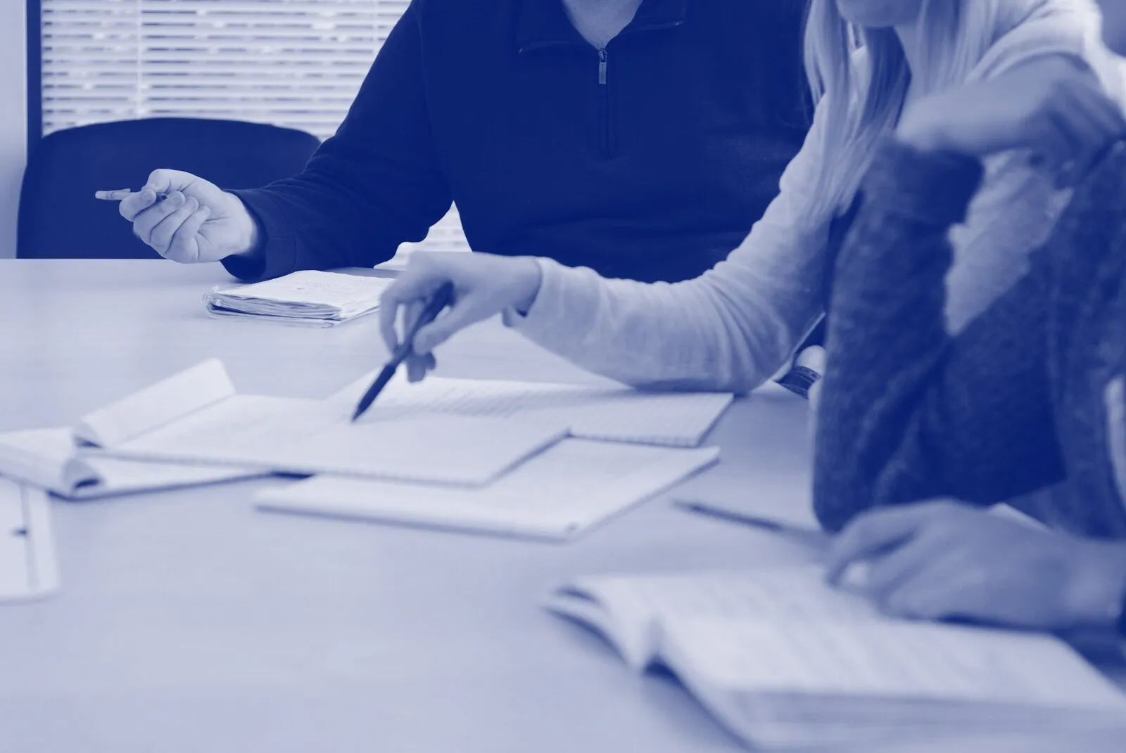 Colleagues working through printed documents together at a table